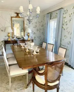 A wooden dining table with 6 white chairs